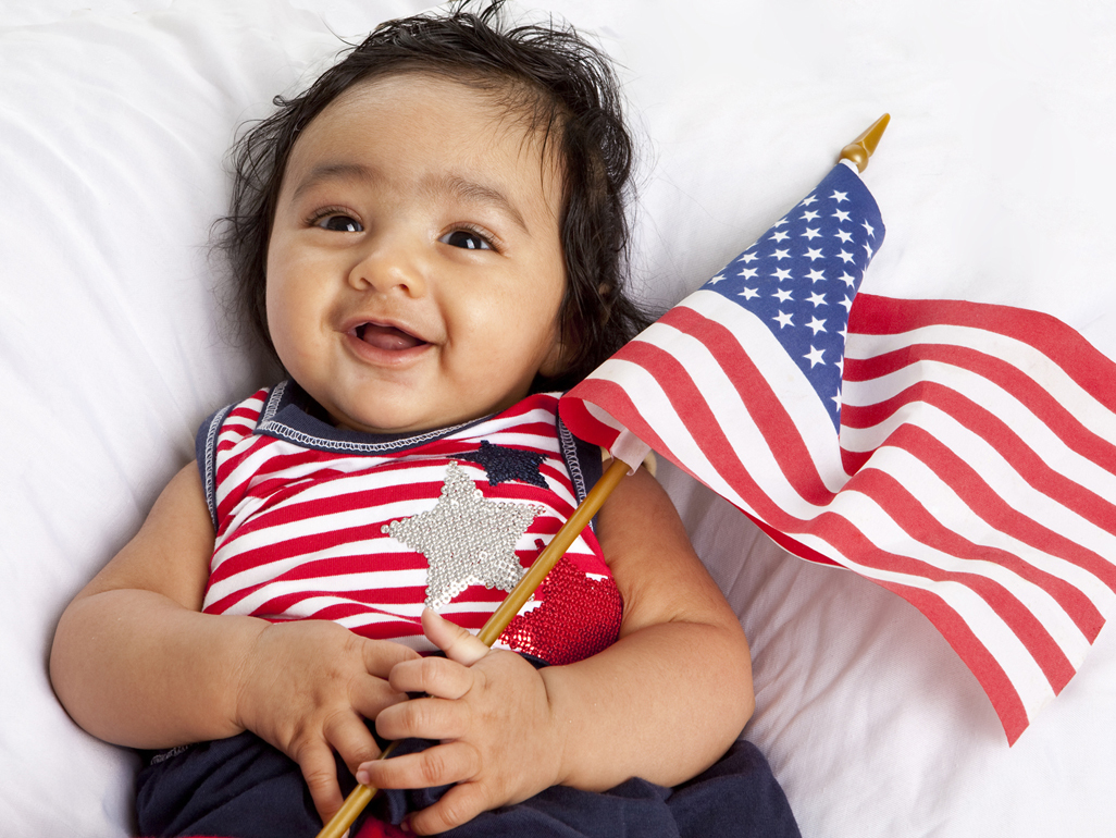 A baby holding an American flag