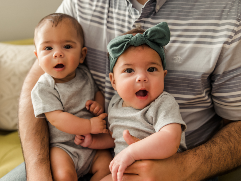 A man holding two babies