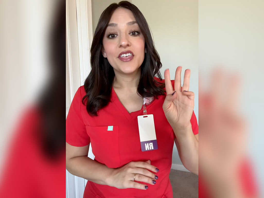 Labor Junkie wearing scrubs, holding up three fingers