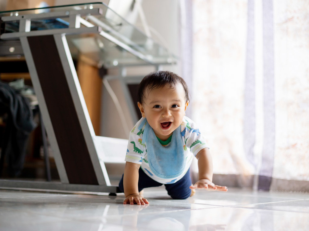smiling little boy crawling on the floor