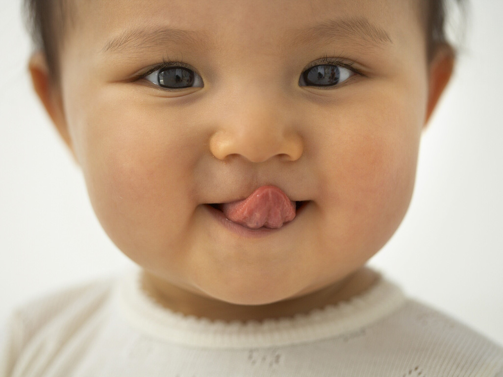 A baby sticking their tongue out