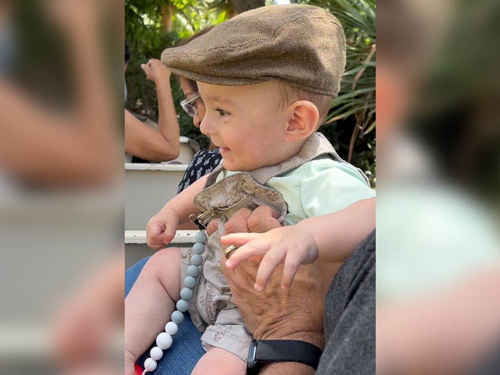 A baby wearing a paperboy hat