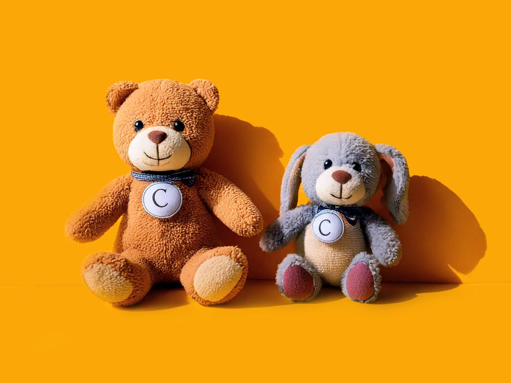 two stuffed animals on a yellow background