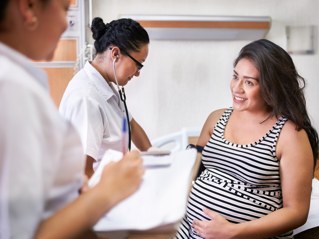 pregnant woman talking to medical assistant