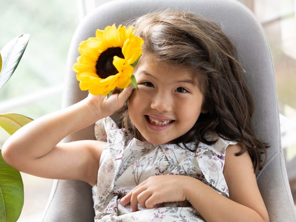 A smiling girl holding a sunflower
