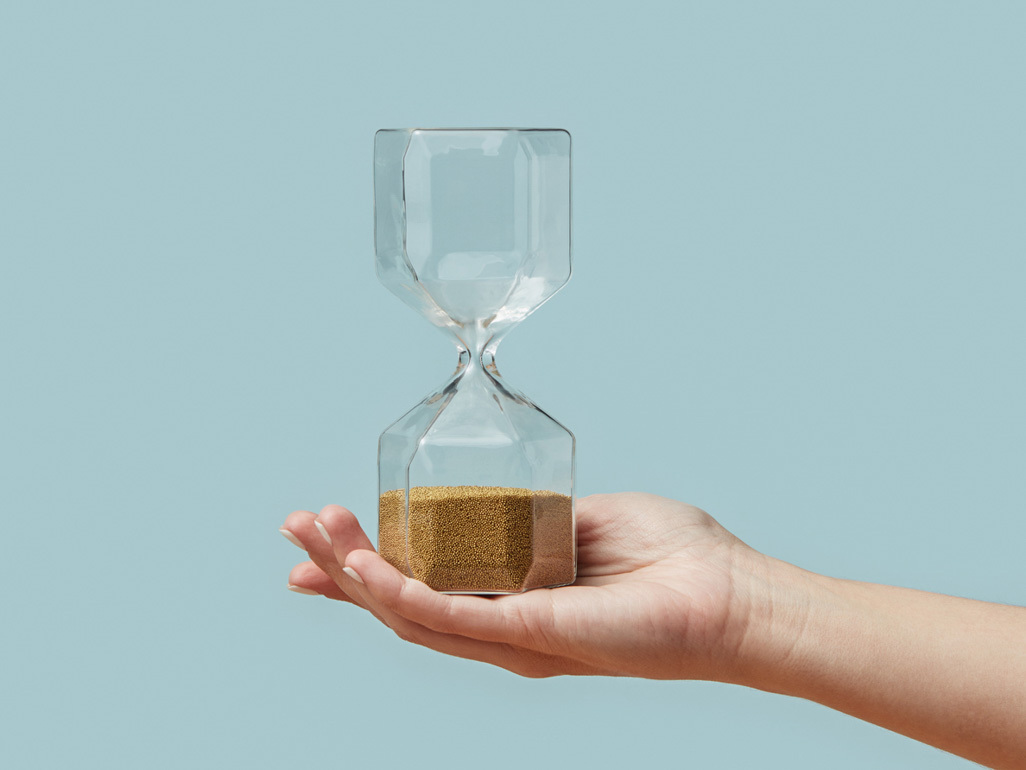a hand holding an hourglass